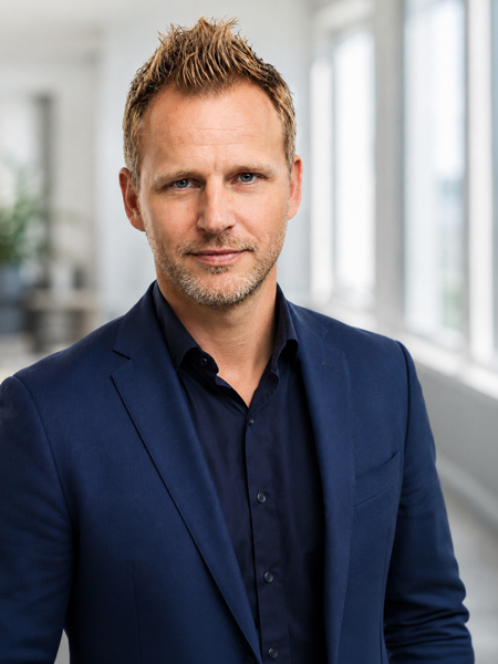 Eric_Weis_COMPRiS_Sales_Director_w | COMPRiS Innovate Sales | COMPRiS Innovate Sales Professional head-and-shoulders photo of a man in a navy blazer and dark shirt, in a bright office setting